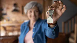 Older homeowner holding a set of keys