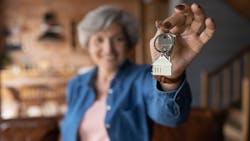 Older homeowner holding a set of keys Older homeowner holding a set of keys
