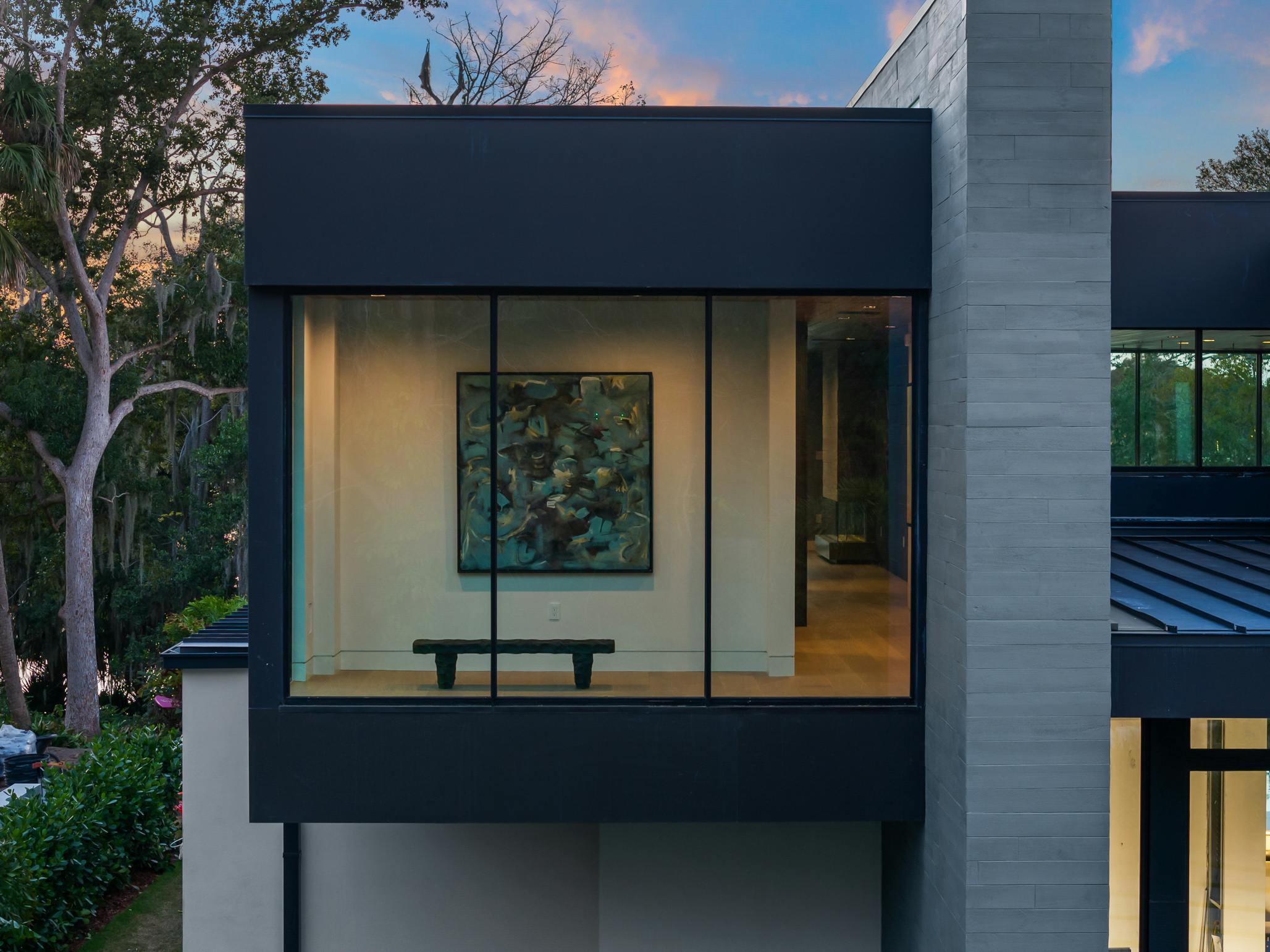 While most viewing areas orient to the lake, a private seating area within the primary suite footprint faces the front, offering a quiet space for the homeowner to enjoy privacy and select pieces of art.