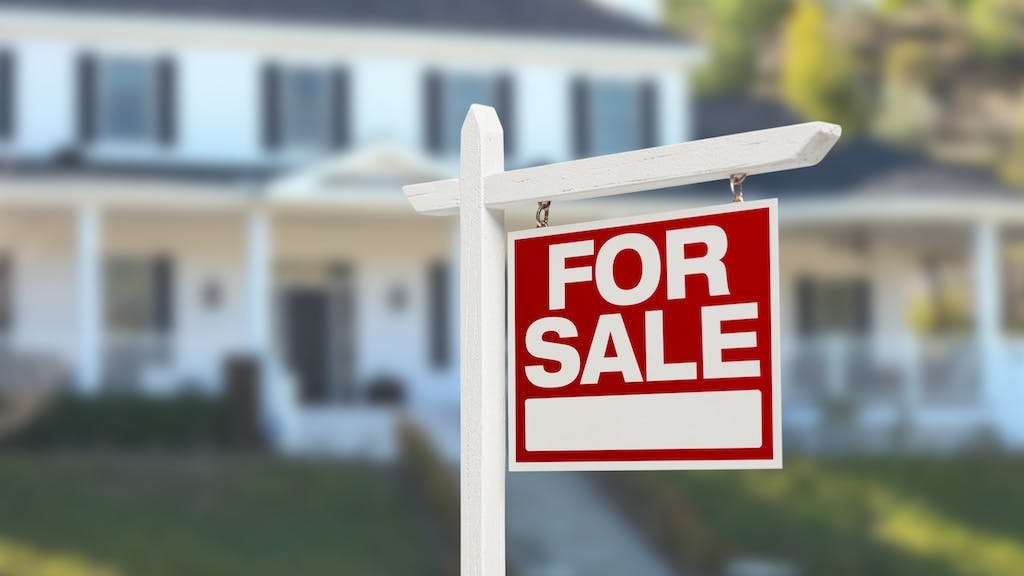 A 'For Sale' sign in front yard