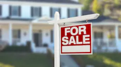 A 'For Sale' sign in front yard