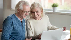 Baby Boomer couple looking at home listings on a laptop Baby Boomer couple looking at home listings on a laptop