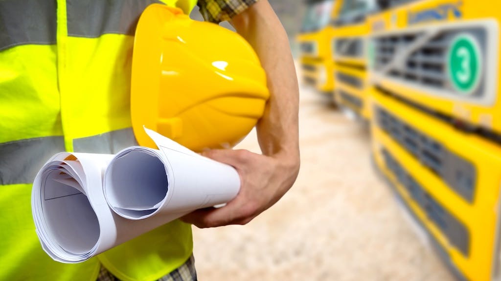 Construction worker holding plans and a hard hat