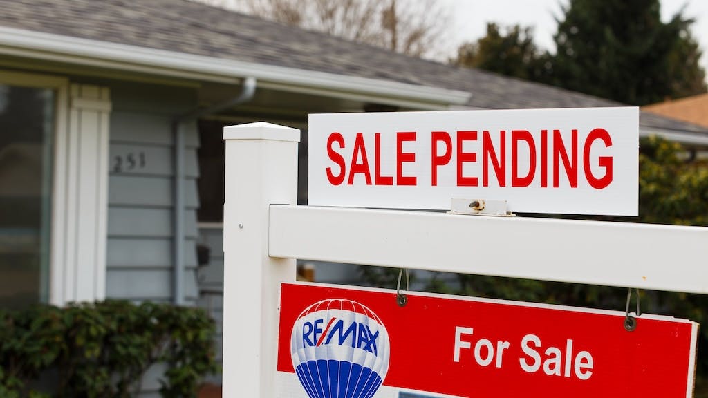 'Sale Pending' sign in a front yard