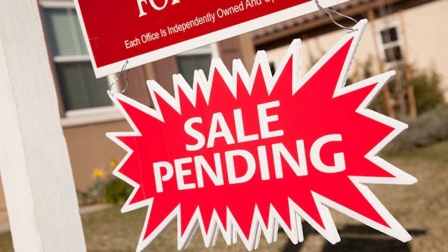 Pending sale sign posted in a front yard