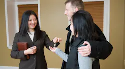 Real estate agent handing a key to homebuyers