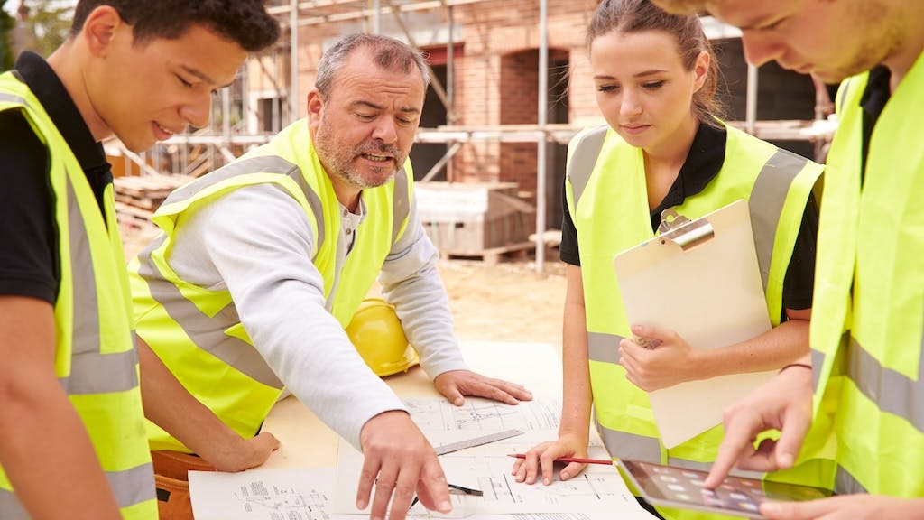 Construction worker trains a group of apprentices