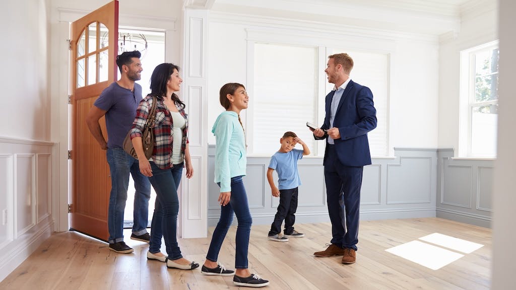 Homebuyers tour a house with a real estate agent