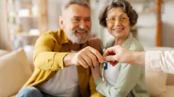 Baby Boomers accepting house keys from a real estate agent