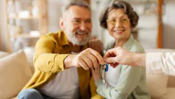 Baby Boomers accepting house keys from a real estate agent
