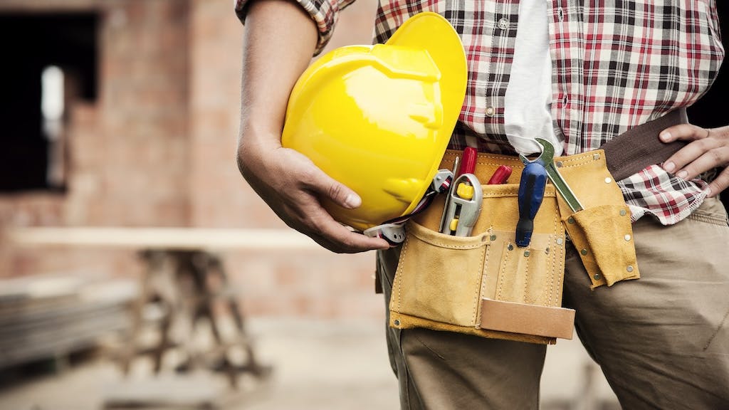 Home builder holding a yellow hard hat