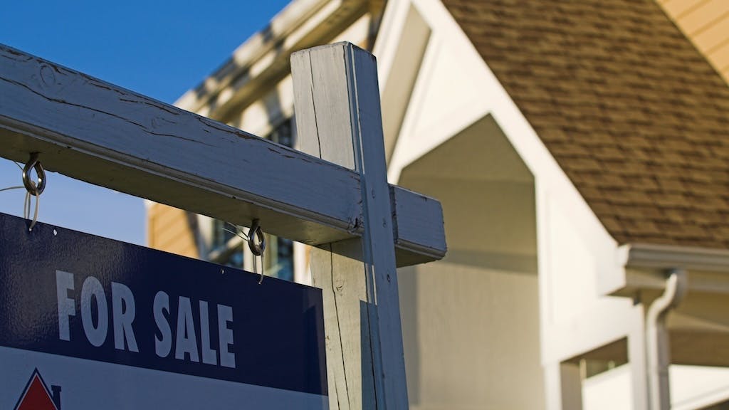 'For Sale' sign posted in a front yard