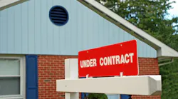 A sign reading 'Under Contract' posted in front of a house