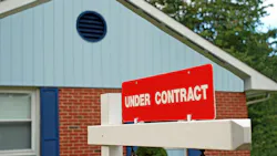A sign reading 'Under Contract' posted in front of a house