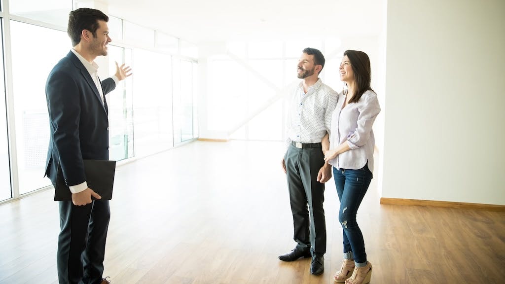 First-time buyers touring a home with a real estate agent