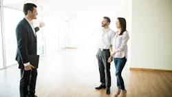 First-time buyers touring a home with a real estate agent