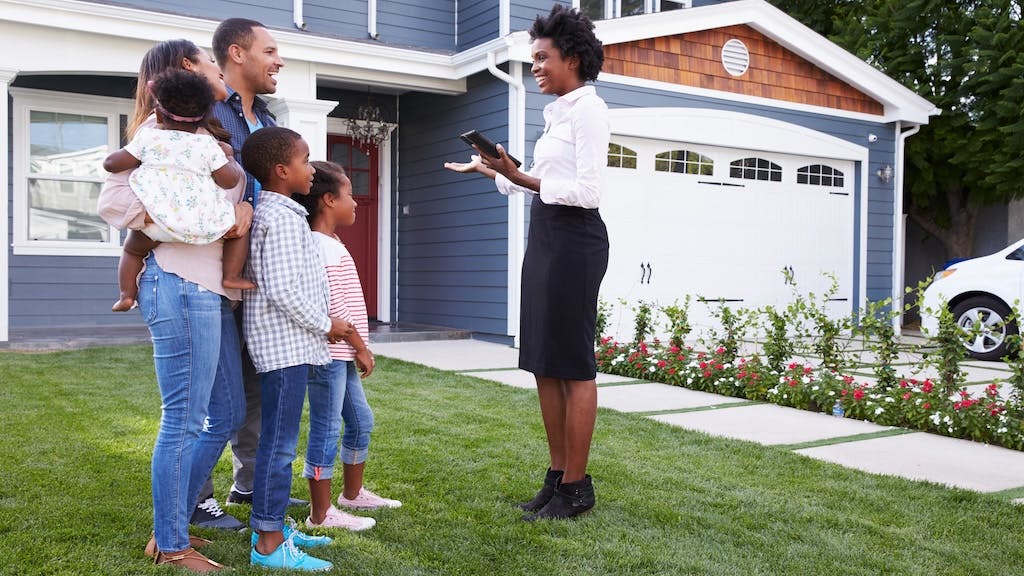 Family touring a luxury home with a real estate agent