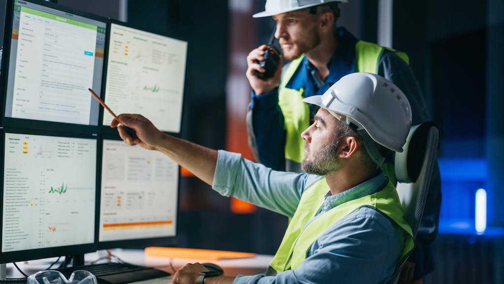 Two engineers work at a computer