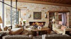 This Big Sky, Mont., living room by Reid Smith Architects showcases an inviting look with warm stone walls, wood details, and earthy furnishings.