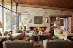 This Big Sky, Mont., living room by Reid Smith Architects showcases an inviting look with warm stone walls, wood details, and earthy furnishings.