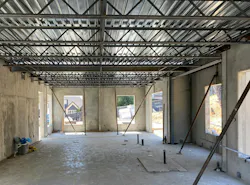 Temporary bracing is used to ensure panels stay in place following placement. Steel floor joists are then attached to the panels followed by installation of steel decking. Cast in place, macro synthetic fiber reinforced concrete meeting the Steel Deck Institute’s (SDI) requirement for replacing steel reinforcement is then pumped onto the metal deck for the composite floor system. Following placement of NileBuilt panels for the second story, the same process is completed again for the roofing system. Closed cell insulation is sprayed onto the bottom side of the metal roof deck for insulating the home.