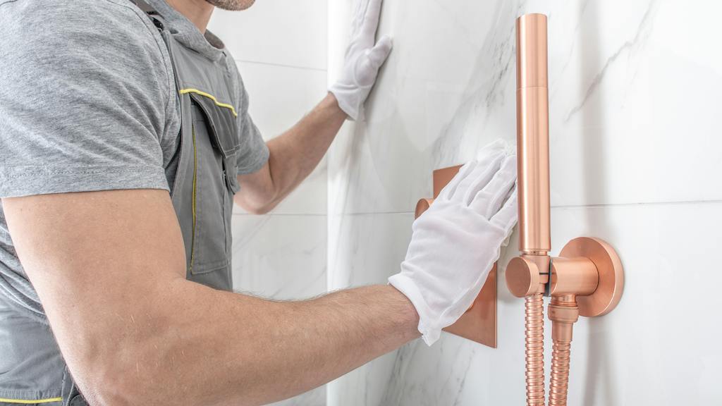Worker installing a showerhead