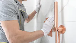 Worker installing a showerhead