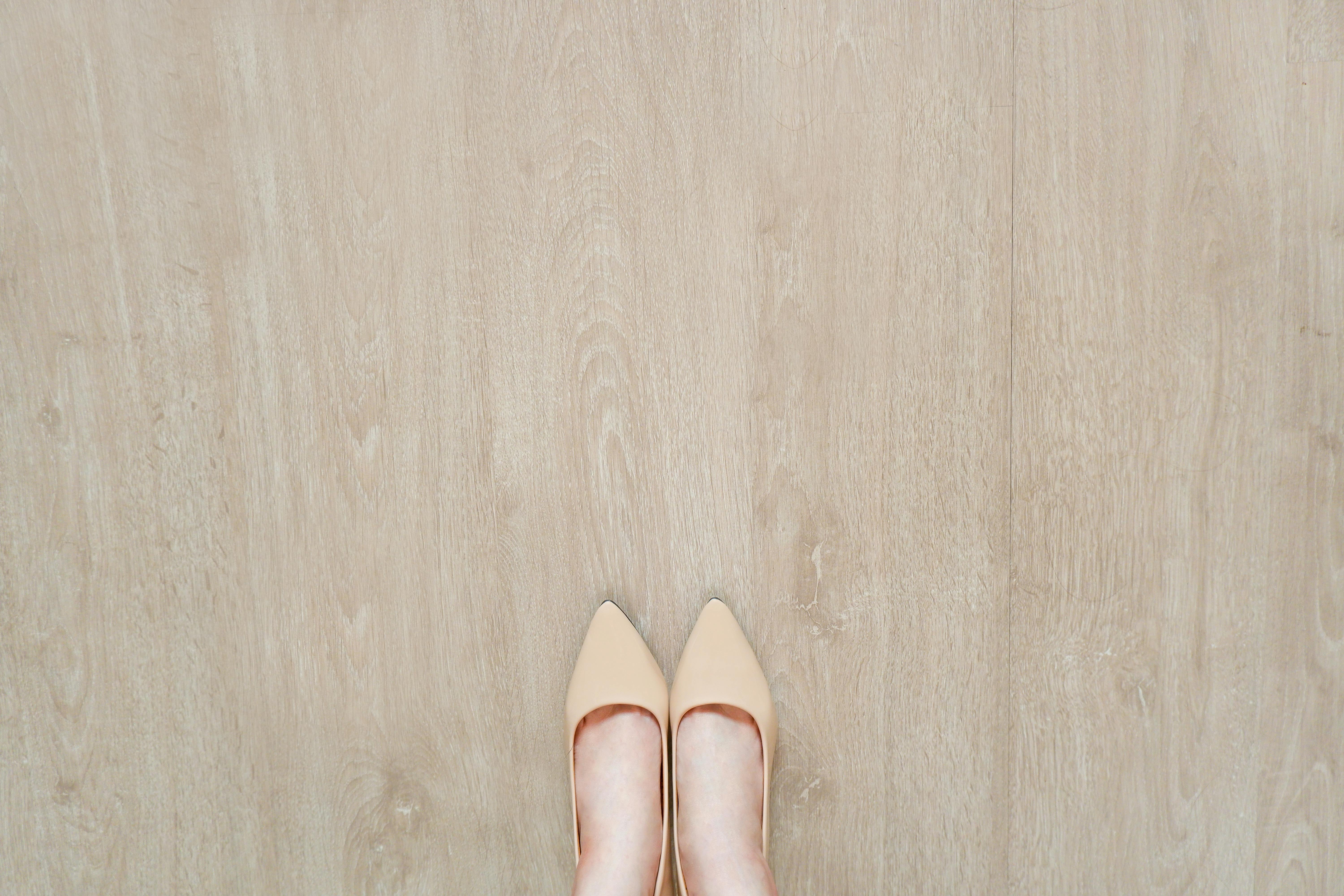 A woman's shoes on a light-colored wood floor