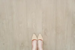 A woman's shoes on a light-colored wood floor